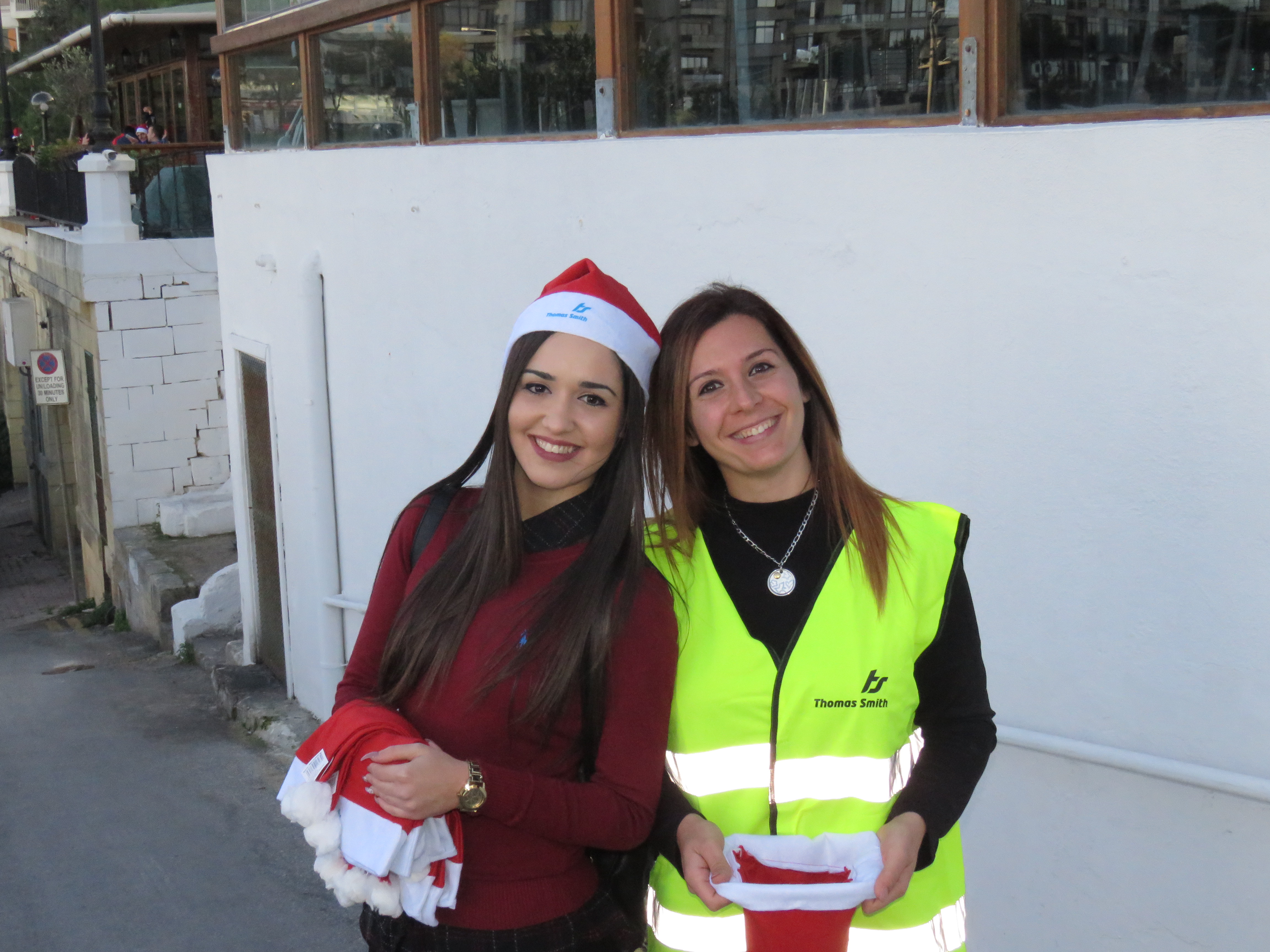 thomas smith employees giving out santa hat during the thomas smith christmas charity swim
